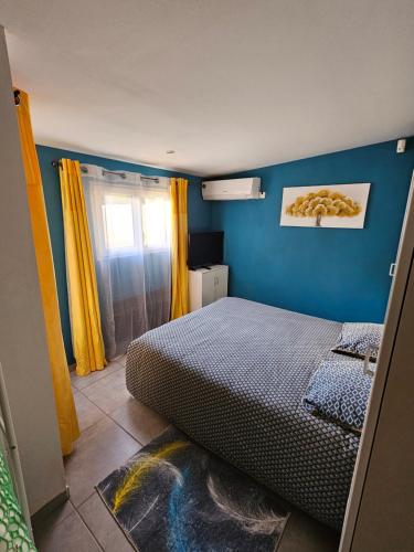 维特罗勒Ni 100%Gite,Ni100% loc chez Kheira&Pascal的一间卧室设有一张床和蓝色的墙壁