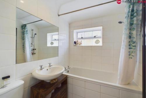 圣艾夫斯relaxed and peaceful的白色的浴室设有水槽、浴缸和水槽。