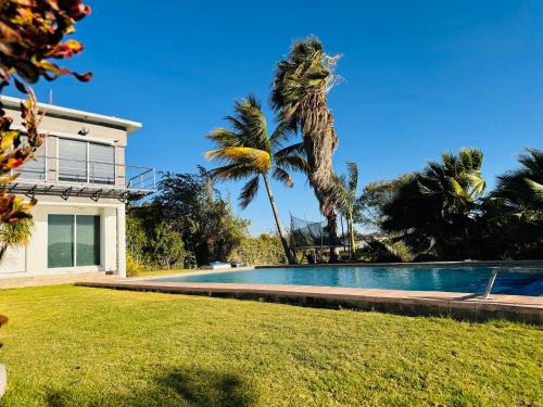 库奥特拉莫雷洛斯Casa Palmeras的一座带游泳池和棕榈树的房子