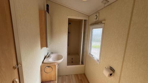 雷讷瑟VZ2405 Vakantiechalet in Renesse的一间带水槽和窗户的小浴室