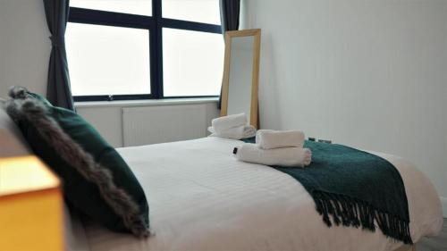 特尔福德Sapphire House Apartments的一间卧室配有一张床,上面有两条毛巾