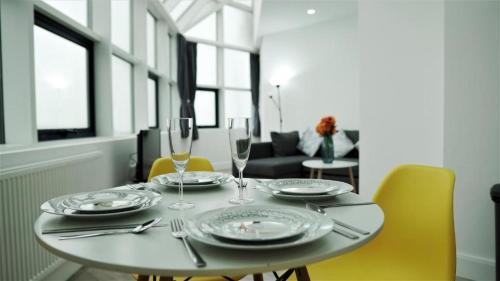 特尔福德Sapphire House Apartments的餐桌,配有盘子和酒杯