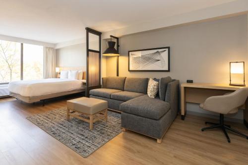 夏洛特夏洛特阿罗伍德凯悦嘉轩酒店的酒店客房配有一张床、一张沙发和一张书桌。