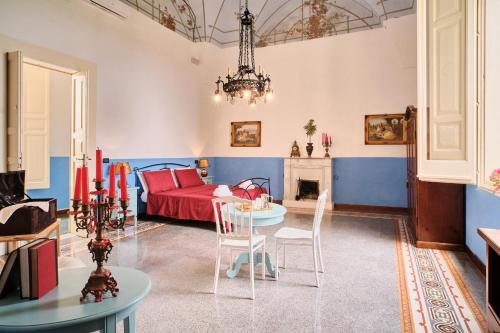 米内尔维诺迪莱切Palazzo Scarciglia的客厅配有红色的床和桌子