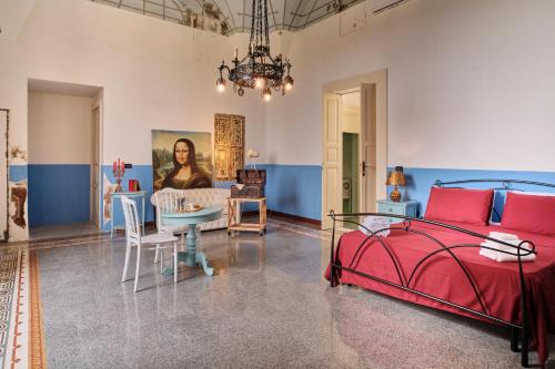 米内尔维诺迪莱切Palazzo Scarciglia的一间带红色床的卧室和一间用餐室
