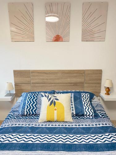 毕斯卡斯Apartamento Espert Biescas的一间卧室配有一张带蓝色和白色枕头的床