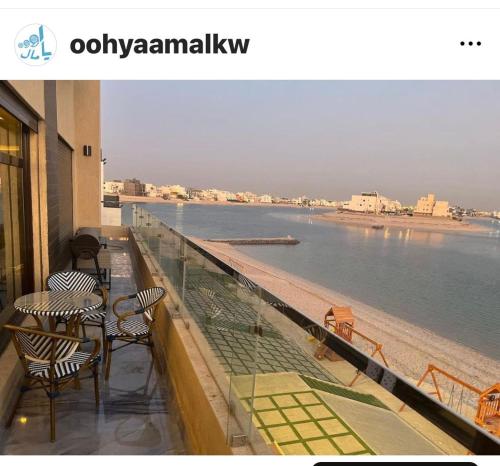 阿尔科兰منتجع اووه يامال البحري في الخيران OOh Yaa Mal的阳台配有桌椅,享有水景。