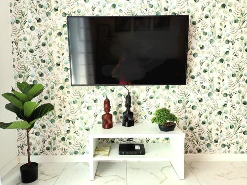 埃尔布隆格Apartament Ania Stare Miasto的墙上的平面电视,配有白色桌子