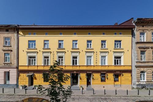 利沃夫Готель Кайзер у Львові的街道上一座黄色建筑,设有白色窗户