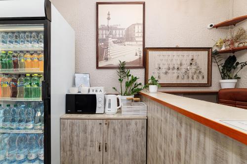利沃夫Готель Кайзер у Львові的厨房设有配备了微波炉和汽水瓶的酒吧