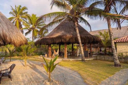 圣贝尔纳多德尔比恩托Paraíso Natural Ecohotel的一个带吊床和两棵棕榈树的度假村