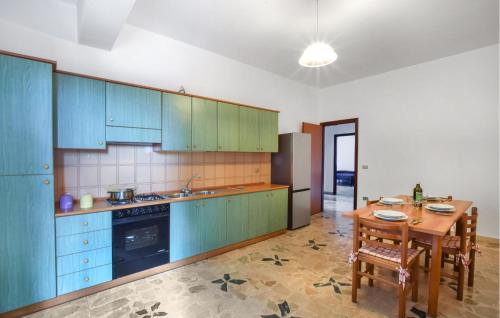 圣费尔迪南多2 Bedroom Cozy Apartment In San Ferdinando的厨房配有蓝色橱柜和木桌