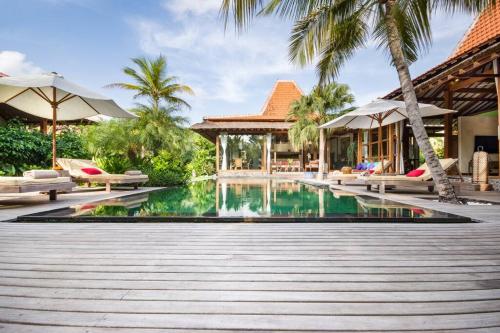 坎古Villa Desa Roro的棕榈树度假村前的游泳池