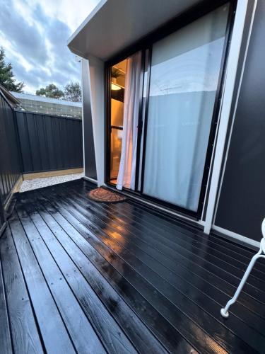 梅尔顿Stylish tiny home in Melton west的房屋内铺有木地板的阳台