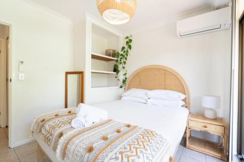 拜伦湾Surfers Rest的一间卧室配有带白色床单和枕头的床。
