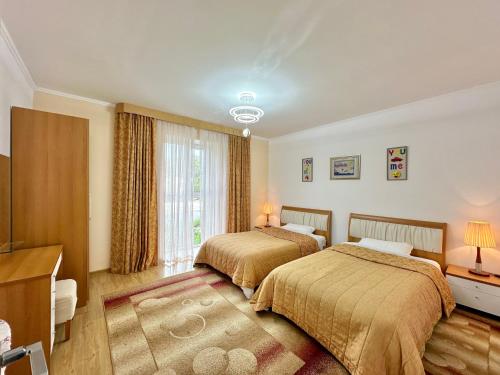 KoshkolʼRaduga West 'Emerald' Cottage的酒店客房设有两张床和电视。
