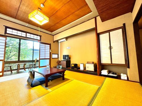 别府日本旅館　松亀荘的客厅配有桌子和黄色地毯