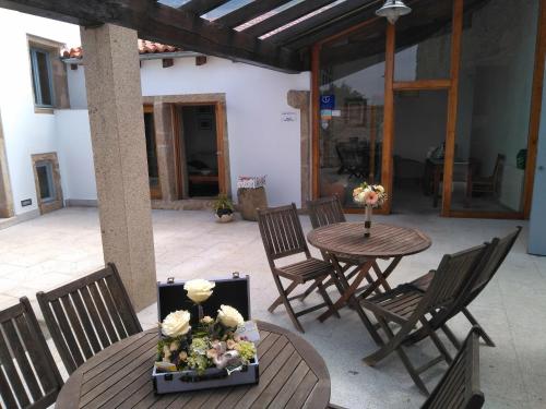 MiñortosCasa do Fieiro的庭院配有椅子和鲜花桌子。