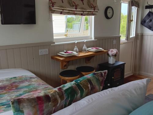 恩尼斯基林Shepherd Hut Bird Enniskillen, Fermanagh的一间卧室配有一张床和一张桌子及凳子