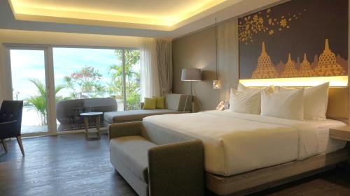 日惹Amaranta Prambanan Yogyakarta的酒店客房设有一张大床和一张沙发。