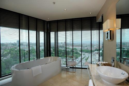 安卡拉安卡拉会议中心大酒店的一间带两个盥洗盆和浴缸的浴室以及窗户。