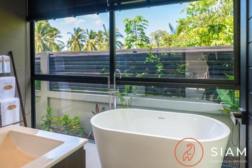苏梅岛K-Baan Villa 2Br & Private Pool的带浴缸的浴室和窗户