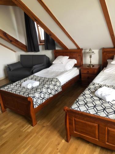 Hotel Gość w dom的一间带两张床和一张沙发的卧室