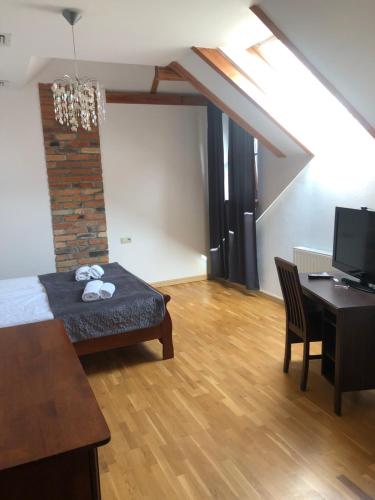 Hotel Gość w dom的客房设有一张床、一张桌子和一张书桌。