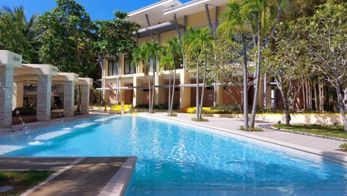 纳苏格布皮克德洛罗公寓的棕榈树建筑前的游泳池