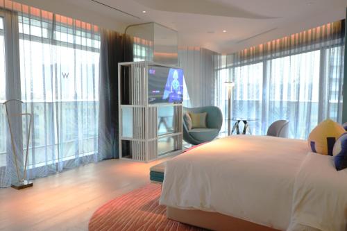 西安西安W酒店的酒店客房设有一张床、一台电视和窗户。