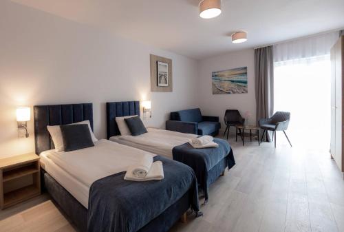 达布基Srebrna Wydma Resort的酒店客房,设有两张床和一张沙发