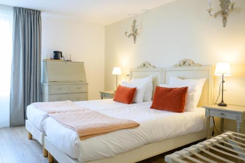 阿尔桑雷玛特里酒店的卧室配有带橙色枕头的大型白色床