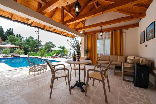 布德瓦Sunset & Sunrise Villas in Stanisici-Two Villas With Common Pool的一间带桌椅的客厅和一个游泳池
