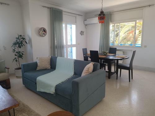 纳布勒Superbe étage de villa vue sur mer的客厅配有蓝色的沙发和桌子