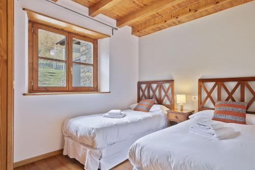 GessaLuderna - Apartamento con terraza Orri A3的带窗户的客房内的两张床