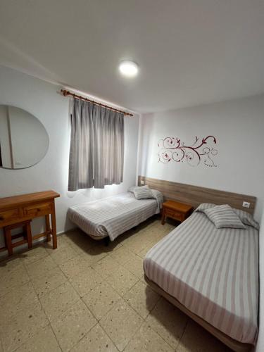 波多黎各布埃纳维斯塔公寓酒店的一间卧室配有两张床、一张桌子和一面镜子