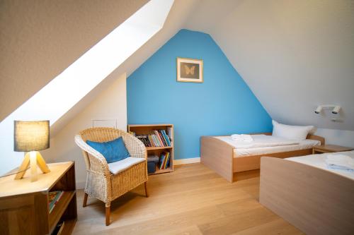布德明Reetdachhaus Holunder 2的一间设有蓝色墙壁、一张床和椅子的房间