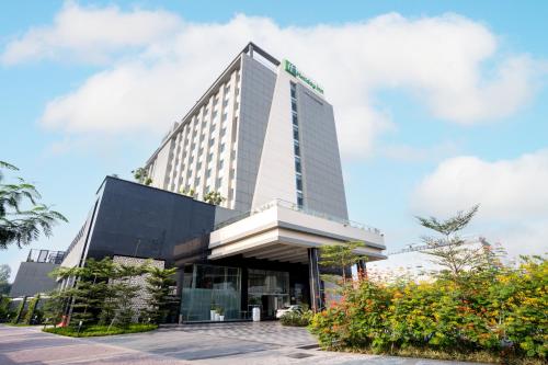 勒克瑙Holiday Inn Lucknow Airport, an IHG Hotel的一座高大的建筑,上面有标志