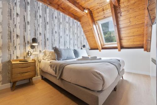 特雷多斯Luderna - Casa Serra Nauta的一间卧室设有一张带木制天花板的大床