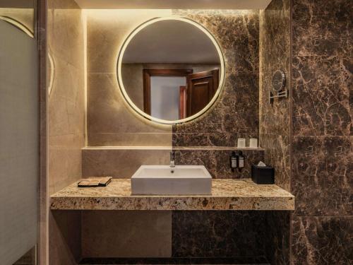十月六日城Mövenpick Hotel Cairo - Media City的一间带水槽和镜子的浴室