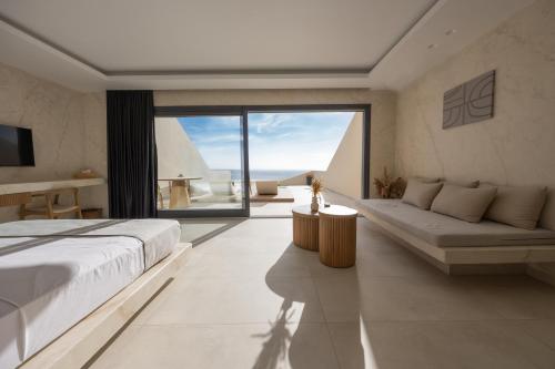 费拉Pnoe Luxury Suites的一间卧室设有一张大床和一个大窗户