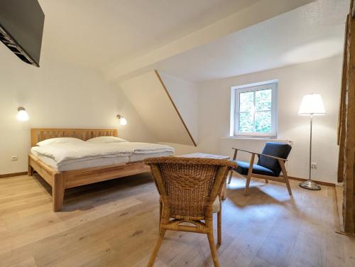 巴特格伦德Waldpension Harzer Waldwinkel的一间卧室配有一张床、一张桌子和一把椅子