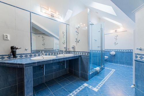 新里斯拉阿玛利亚酒店的蓝色和白色的浴室设有两个水槽和淋浴