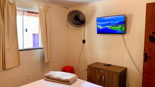 阿布拉奥Morada Massala - Abraão - IG的卧室设有壁挂式电视和床。