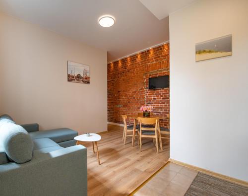 克莱佩达Red Brick Apartments的带沙发和砖墙的客厅