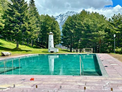 福米加尔APARTAMENTO súper céntrico, con vistas a pistas y Wifi的一座带灯塔和山脉的游泳池