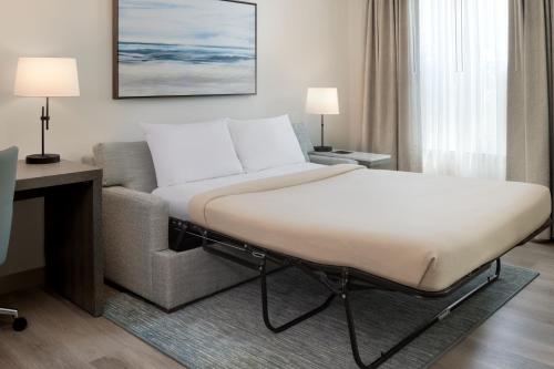 德斯坦圣丹斯汀格兰德大道住宿酒店的在酒店客房内的床和沙发