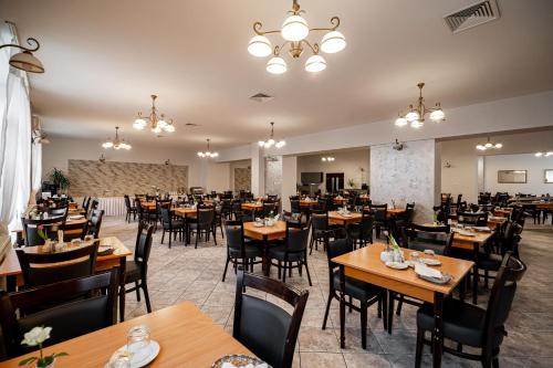 克雷尼察Nowe Łazienki Mineralne的用餐室配有木桌和椅子