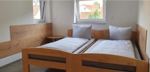 辛斯海姆Eibauer Apartments的带2扇窗户的小客房内的2张床