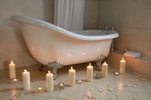 Aherlow阿尔罗小屋酒店的带浴缸和蜡烛的浴室(位于地板上)